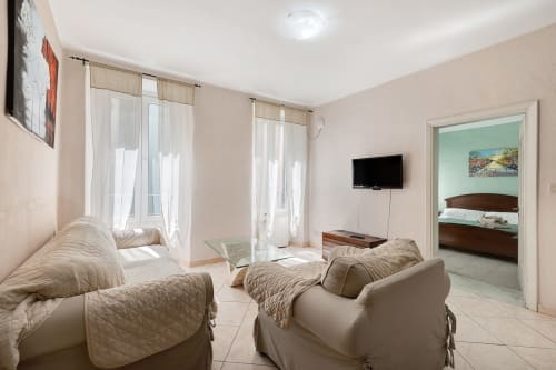 Appartamento Annamaria a Casa Scola Loano con divani beige, televisore e accesso alla camera da letto