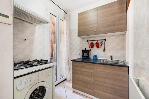 Cucina moderna nell'appartamento Annamaria a Casa Scola Loano con fornelli a gas, mobili in legno e lavatrice