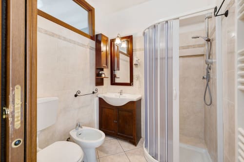 Bagno spazioso nell'appartamento Annamaria di Casa Scola Loano con mobile lavabo in legno, doccia e bidet