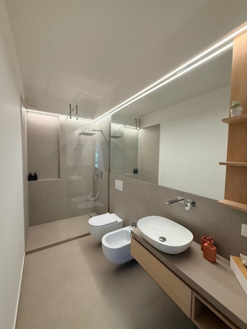 Modern bathroom at Adagio Ravello with oval sink, bidet, toilet, walk-in shower, and wooden shelving