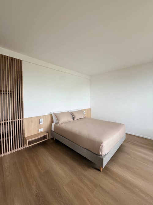 Modern bedroom at Adagio Ravello with queen bed, wooden headboard, beige bedding, and minimalist décor