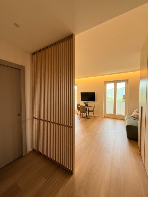 Modern studio apartment at Adagio Ravello with wooden partition, hardwood floors, kitchenette, and sea view terrace access