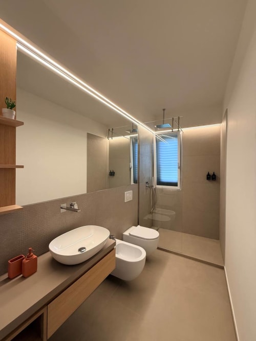 Modern bathroom at Adagio Ravello with vessel sink, toilet, bidet, walk-in shower, LED lighting, and wood accents
