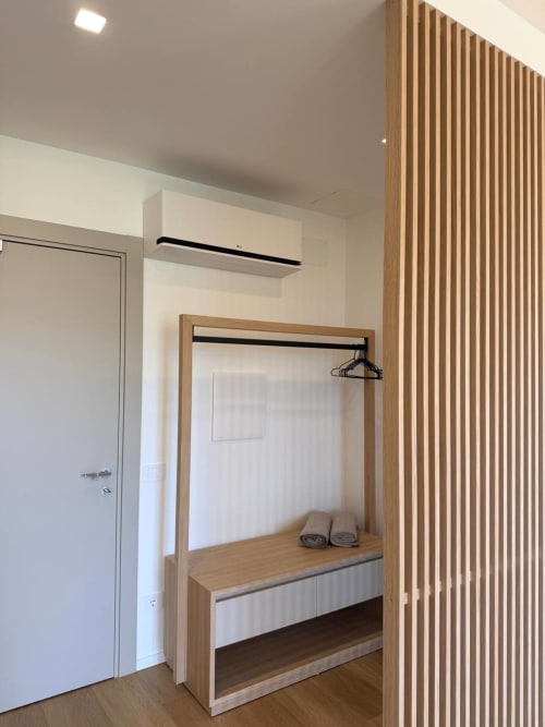 Modern wardrobe with wooden frame and hanger rail in Adagio Ravello hotel room Boogie, featuring white panel and shelving