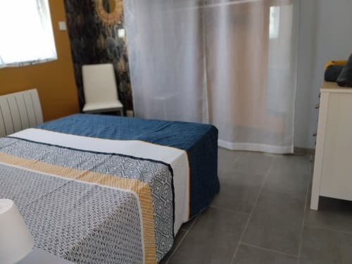 Le Petit Baigneur cottage bedroom at La Pause Landaise with blue bedding, terrace, and pool view in Magescq