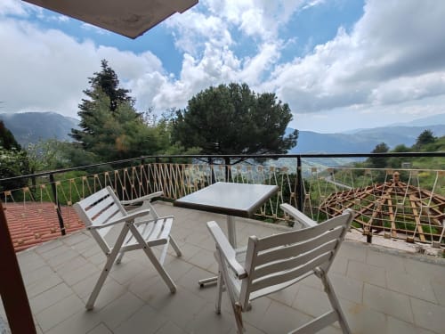 Terrasse Infinito de l'Allegria Affittacamere à Bajardo avec vue sur les montagnes, chaises blanches et table