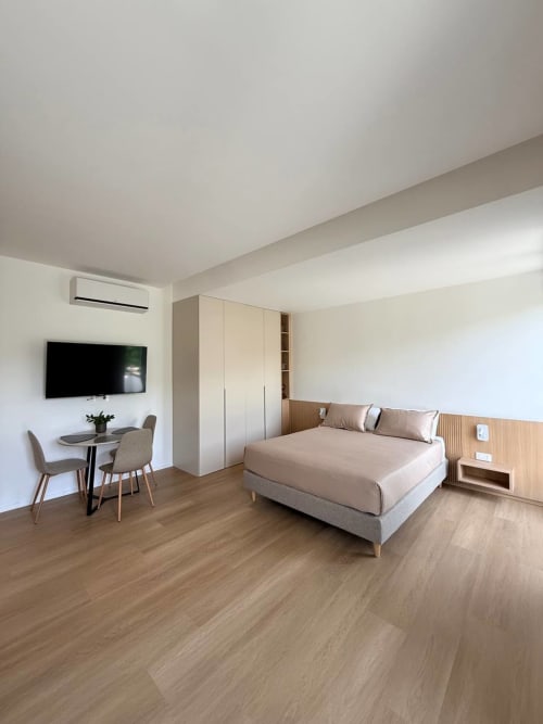 Modern bedroom at Adagio Ravello villa in Ravello with queen bed, work desk, TV, and wooden flooring