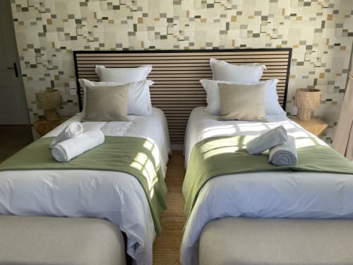 Lits jumeaux à La Closerie B&B à La Redorte avec draps blancs, oreillers décorés et serviettes roulées