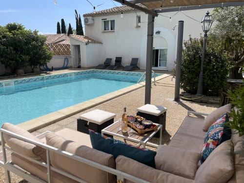 Espace piscine de La Closerie BnB à La Redorte avec transats, coin détente et hébergements aux murs blancs