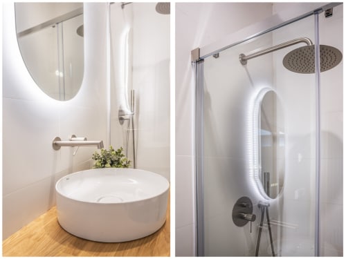 Baño moderno en Los Patios de Feria, Sevilla: lavabo redondo blanco con espejo iluminado y ducha con mampara de cristal