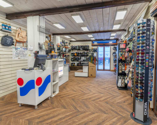 Intérieur de boutique au Chalet des Cimes à Belle Plagne présentant équipement outdoor, matériel et souvenirs.