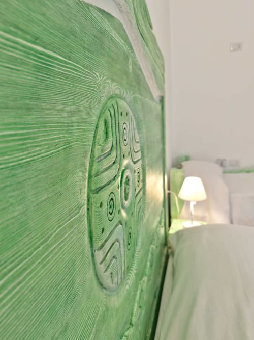 Parete in verde con motivi decorativi presso le Regnos Altos Boutique Rooms a Bosa, con lampada da comodino visibile