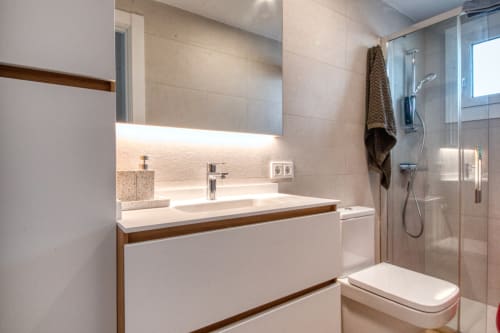 Modern bathroom with vanity, mirror, and shower at Finques Garcia Enrich apartment in Palafrugell