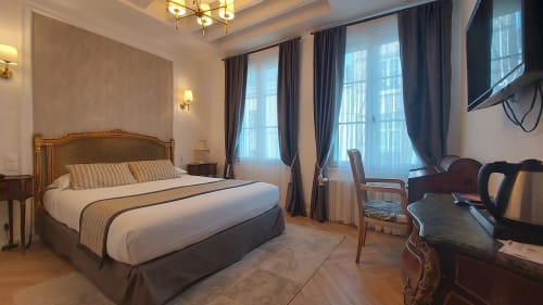 Chambre élégante à l'Hôtel Dandy à Rouen avec lit doré, literie rayée, baies vitrées et style classique