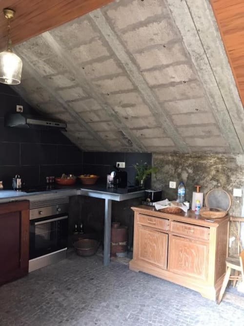 Cozinha moderna na villa Adega Garcês em Casa Estrelícia-Dourada Garcês, São Vicente, com teto de concreto e marcenaria preta.