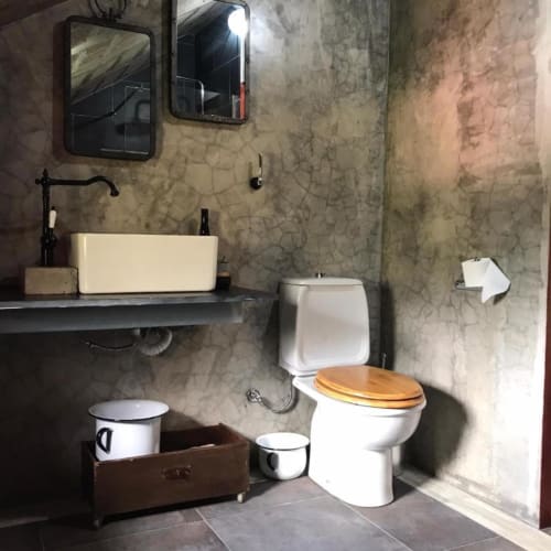 Banheiro rústico na vila Adega Garcês em Casa Estrelícia-Dourada Garcês, São Vicente, com assento de madeira e pia de louça