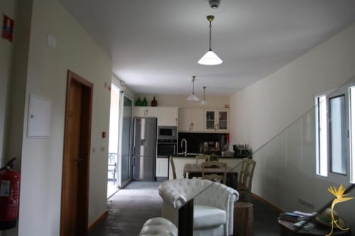 Sala de estar em plano aberto na pousada Casa Mãe em A Casa Estrelícia-Dourada Garcês, São Vicente, com cozinha, mesa de jantar, sofá,