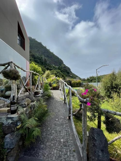 Caminho do jardim da villa Casa Estrelícia-Dourada Garcês em São Vicente com vistas de montanha e flores rosa