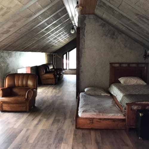Quarto espaçoso da villa A Casa Estrelícia-Dourada Garcês, São Vicente, com cama de madeira, móveis em couro e estilo industrial