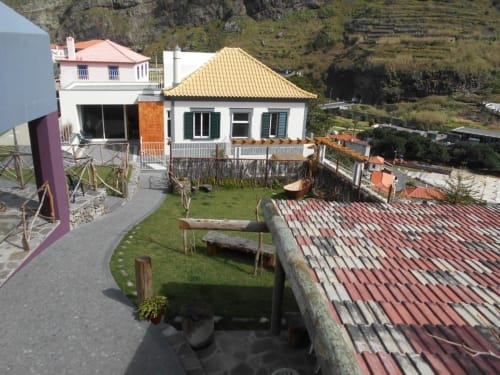 Casa Mãe: chalé com telhado dourado, paredes brancas e terraço de jardim com vista para a serra de São Vicente, Portugal