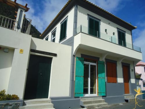Apartamento T2 Casa Estrelícia-Dourada Garcês, rés-do-chão em São Vicente, fachada branca, portadas turquesas e montanha