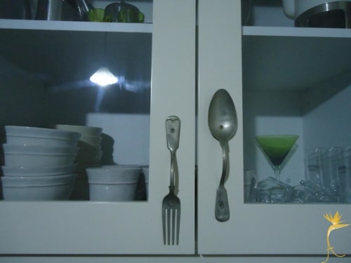 Utensílios de cozinha expostos em armário de vidro na pousada Casa Estrelícia-Dourada Garcês, São Vicente