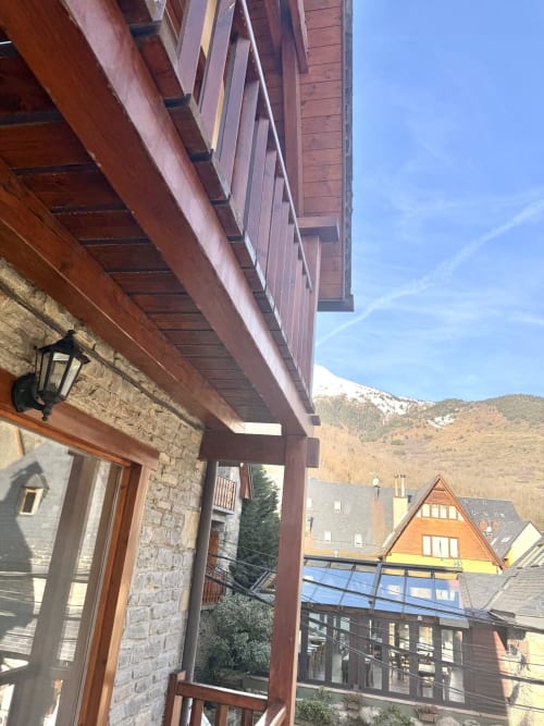 Vista de montañas nevadas desde el balcón de un apartamento en Vielha con arquitectura alpina