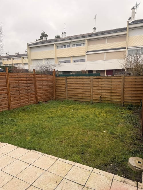 Jardin clôturé avec barrière en bois de l'appartement Kawichimmo Locations à Louvres, France