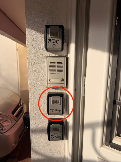 Prises électriques murales et interphone dans l'appartement du 1er étage de Kawichimmo Locations à Louvres, France, avec détail rouge