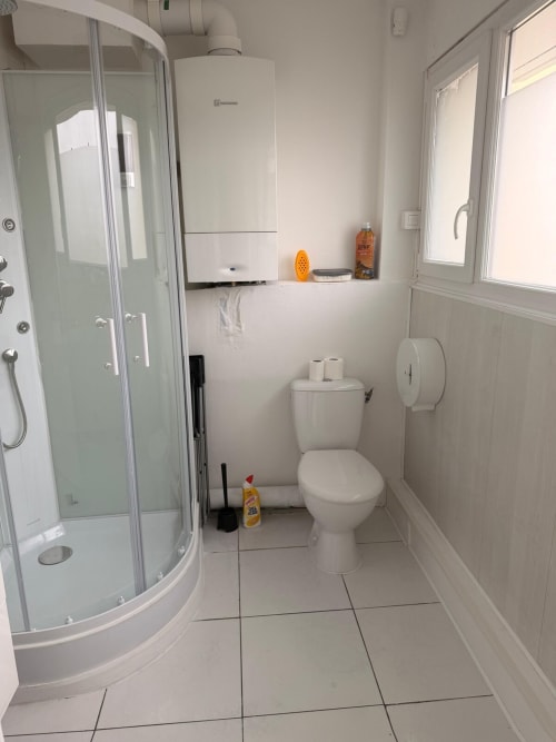 Salle de bain moderne dans l'appartement 2 chambres de Kawichimmo Locations à Louvres, avec équipements blancs et douche