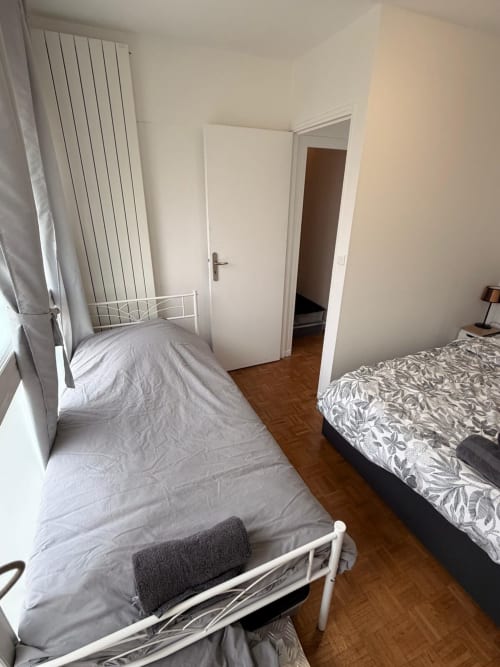 Chambre lumineuse du appartement 2 pièces Kawichimmo, avec deux lits jumeaux, volets et parquet