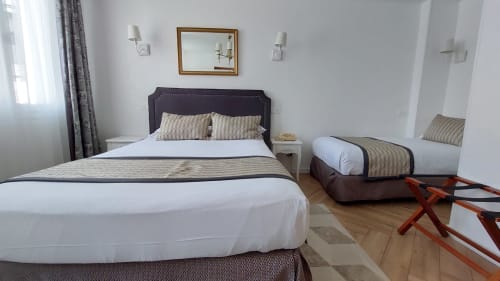 Chambre moderne de l'Hôtel Dandy à Rouen avec lits jumeaux, oreillers rayés, parquet et luminaires contemporains.