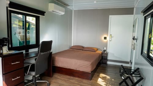 Habitación moderna en Contenedores Boutique Hotel con cama, escritorio, aire acondicionado y vistas al jardín