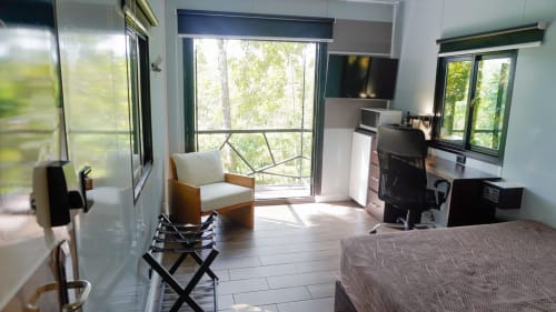 Habitación moderna del Contenedores Boutique Hotel en Costa Rica con vistas al jardín, cama, escritorio, TV y baño privado