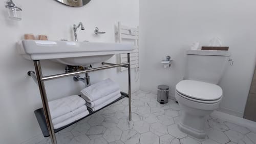 Salle de bain moderne de l'Hôtel Dandy à Rouen avec lavabo blanc, toilettes et carrelage hexagonal