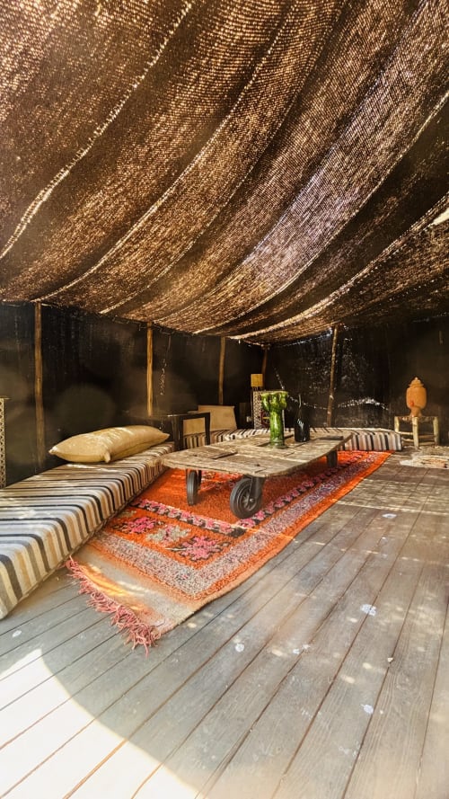 Tente lounge Maison la Chèvre Essaouira avec sièges rayés, plafond tissé et tapis colorés