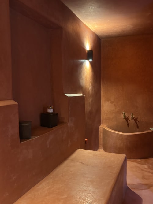 Warm terracotta bathroom at Maison la Chèvre Essaouira with modern fixtures and ambient lighting