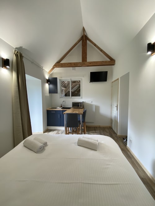 Studio confort cottage at Domaine des Piéris with bed, kitchenette, and wooden beamed ceiling
