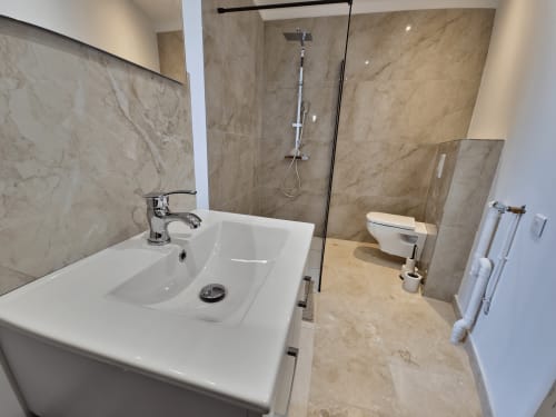 Modern bathroom at Smooth Luberon Apt Belvedere with marble tiling, white sink, rainfall shower, and toilet in Villars