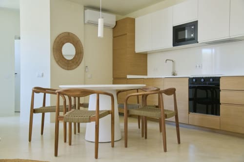 Modern kitchen-dining area in Casa Redonda apartment, Aroeira with wooden chairs and white cabinetry