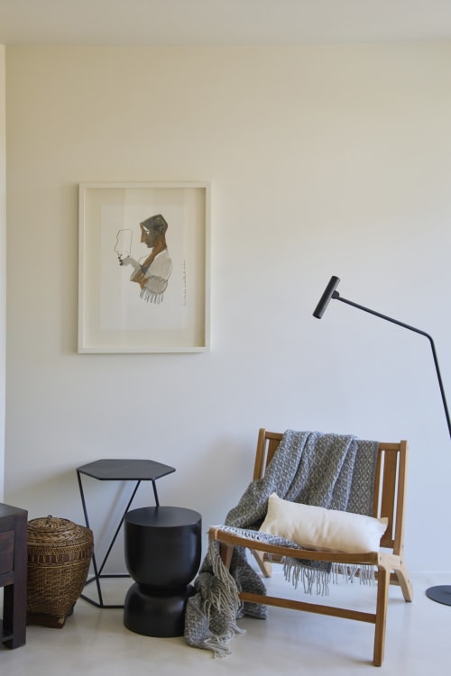 Modern seating area in Casa Redonda apartment with wooden chair, black accent tables, and framed artwork, Aroeira