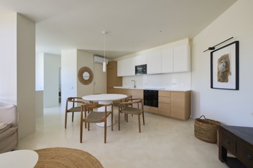 Modern open-plan apartment at Casa Redonda, Aroeira with dining area, wooden furniture, and integrated kitchen