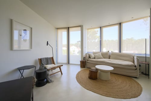 Moderna sala de estar em Casa Redonda, Aroeira com sofá bege, móveis de madeira e vista para o jardim