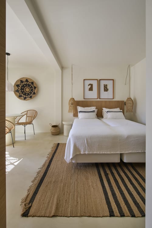 Quarto minimalista em estúdio na Casa Redonda, Aroeira com duas camas, detalhes em tecelagem e vista para o jardim