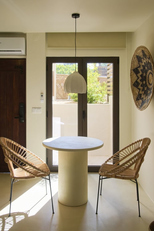 Área de jantar moderna em Casa Redonda, Aroeira com mesa redonda, cadeiras tecidas e luminária pendente