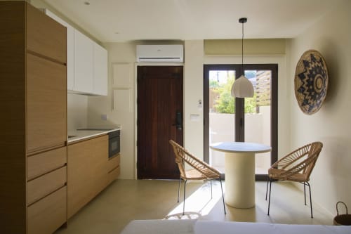 Cozinha e sala de jantar modernas na Casa Redonda by Villas Aura em Aroeira, com cadeiras de rattan e vista para o jardim