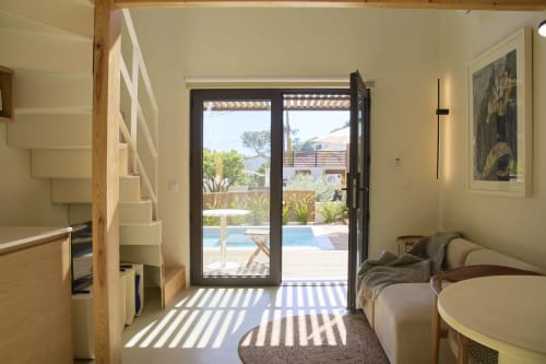Bright duplex bedroom at Casa Redonda, Aroeira with wood stairs, pool view through glass doors, and modern furnishings