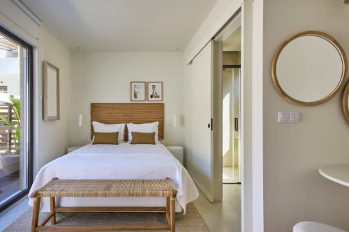 Bright bedroom at Casa Redonda with wooden bed, white linens, pool view, and modern amenities in Aroeira