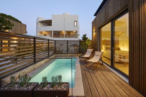 Casa Redonda pool villa in Aroeira with illuminated terrace, turquoise pool, loungers and modern architecture at dusk