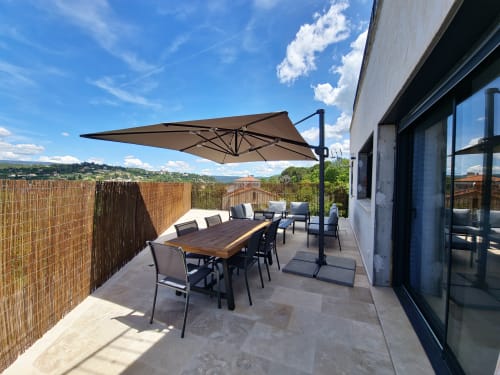Sunny terrace at Smooth Luberon Villars with dining table, umbrella, and mountain views over Provence